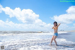 A woman in a bikini standing in the water.