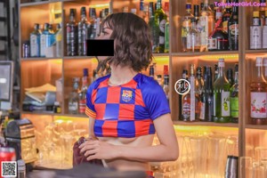 A woman sitting on a bench with a soccer ball.