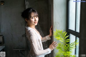 A woman in a red kimono standing in a room.