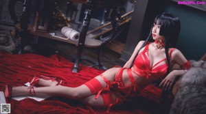 A woman in a red lingerie posing for the camera.