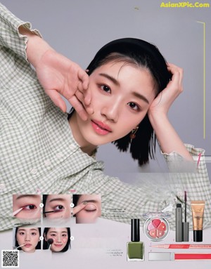 A woman sitting at a table with a variety of makeup products.