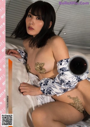 A woman in a white lingerie is posing for the camera.
