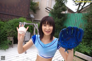 A woman in a blue and white uniform holding a baseball bat.