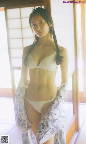 A woman in a white underwear laying on the floor.