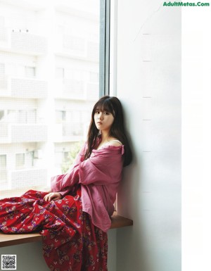 A woman in a red and white dress posing for a magazine.