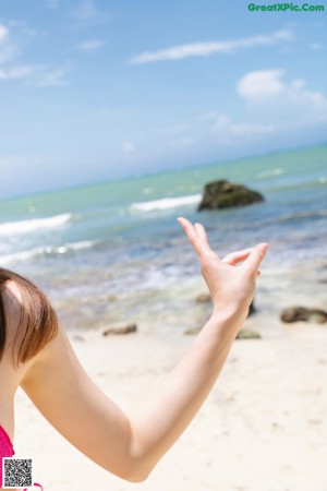 A woman in a pink bikini drinking a drink.