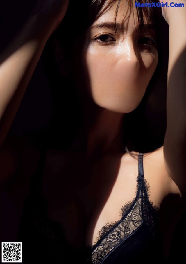 A woman in a black lingerie posing for a picture.