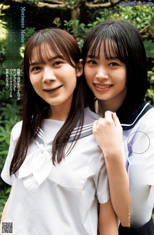 A couple of young women sitting on top of a chair.