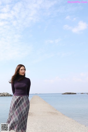 A woman in a purple sweater is posing for a picture.