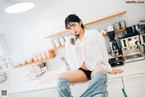 A woman sitting at a desk smoking a cigarette.