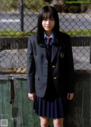 A woman with long black hair wearing a suit and tie.