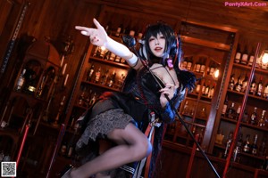 A woman in lingerie sitting on a bar with a cane.