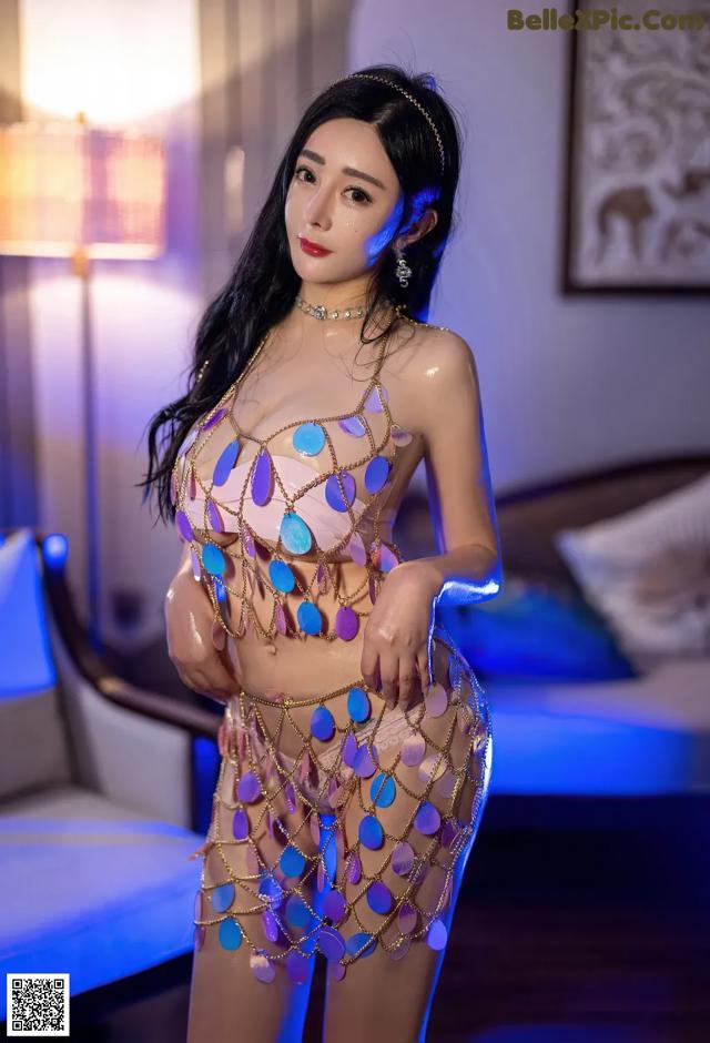 A woman in a gold and blue outfit posing for a picture.