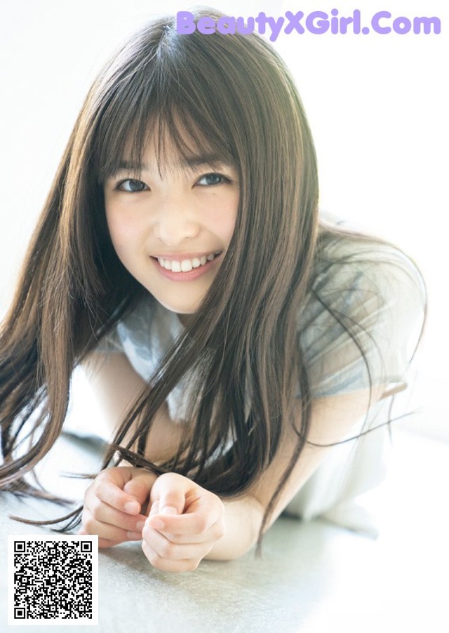 A young woman laying on the floor with long brown hair.