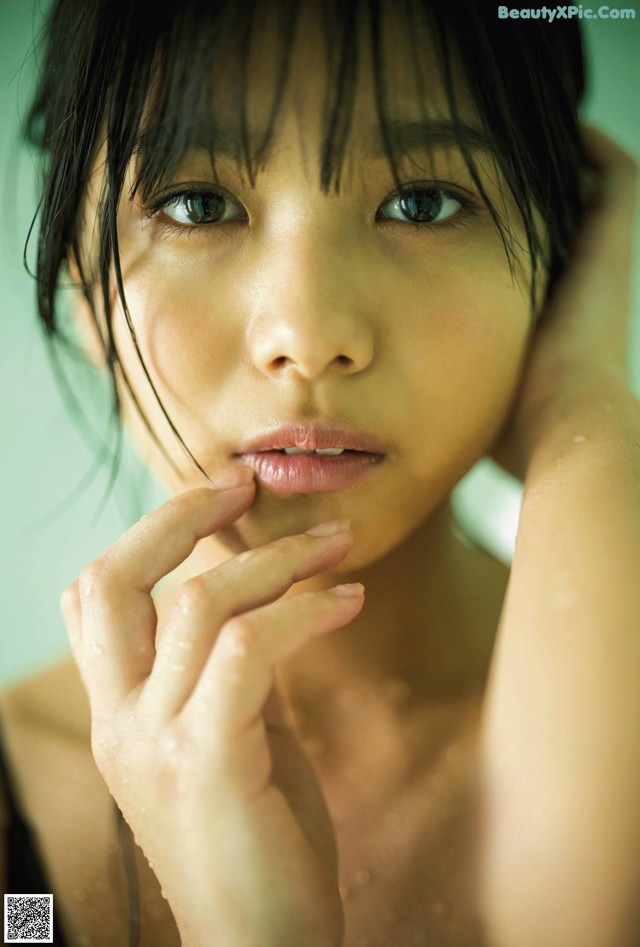 A woman with wet hair and blue eyes posing for a magazine.