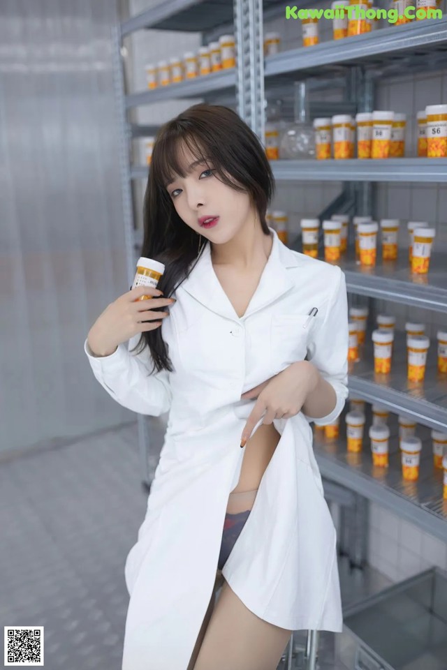 A woman in a white lab coat holding a cup of coffee.