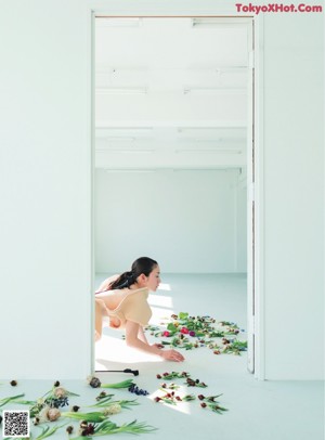 A woman laying on the ground next to a bunch of flowers.