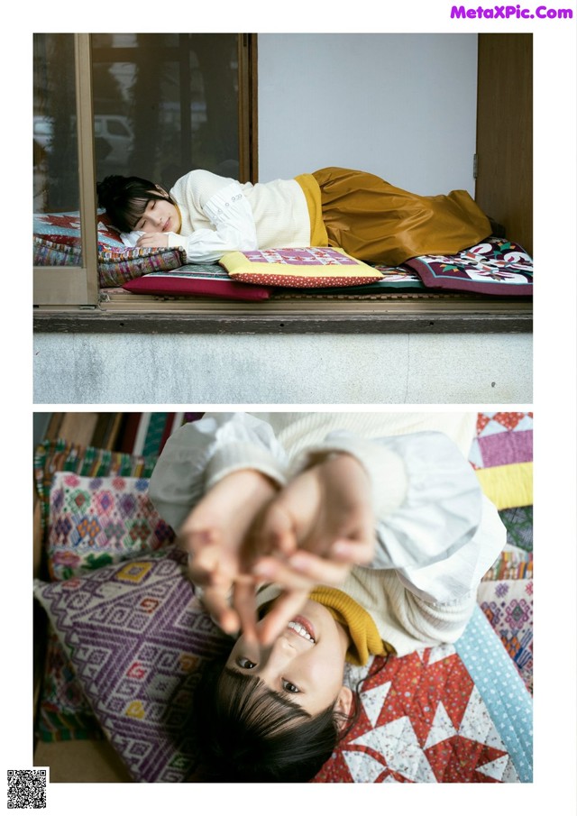 A little girl laying on top of a bed next to a window.