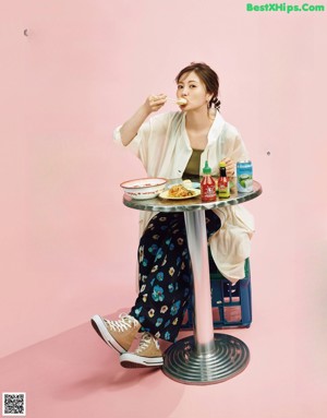 A woman sitting at a table with a plate of food.