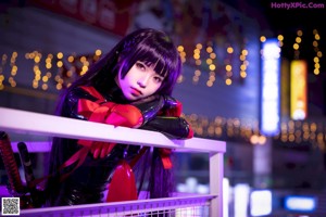 A woman in a red and black outfit is posing for a picture.