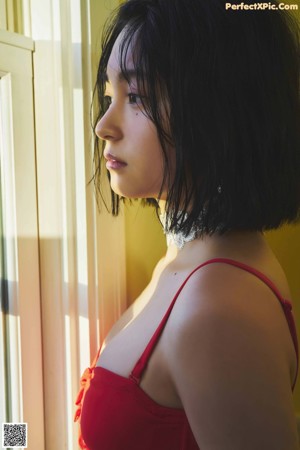 A woman in a red and white lingerie posing for a picture.