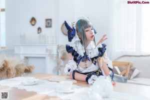 A woman in a blue and white dress sitting on a table.