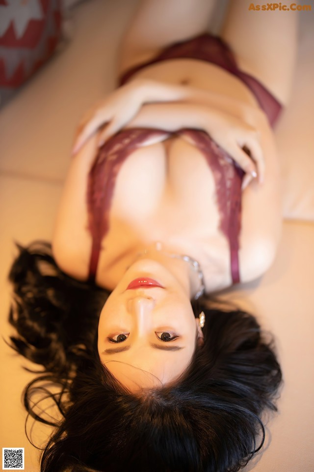 A woman laying on top of a bed in lingerie.